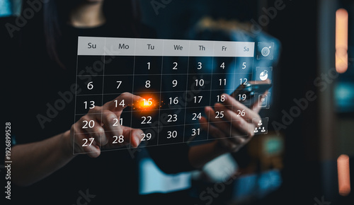 A person interacts with a futuristic transparent digital calendar interface, highlighting a specific date with glowing effects.