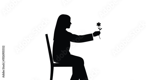 Woman seated delicately holding a flower in a stark silhouette