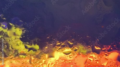 Vibrant underwater scene with yellow and orange fish swimming near a colorful coral reef in a dark blue ocean with a shallow depth of field conveying a sense of wonder and exploration.