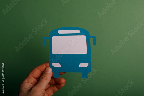 Hand holding a paper bus cu...