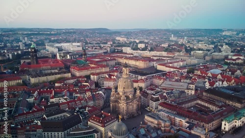 A pulling back aerial shoot of Dresden's Old Town and the River Elbe unfolds behind the Frauenkirche n Dresden in Germany at dawn