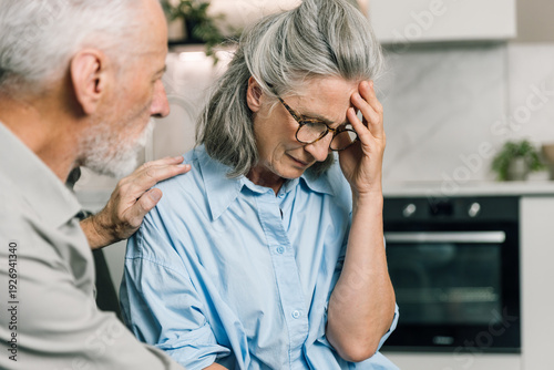 Konstfotografi Elderly man comforts distressed woman suffering from headache at home