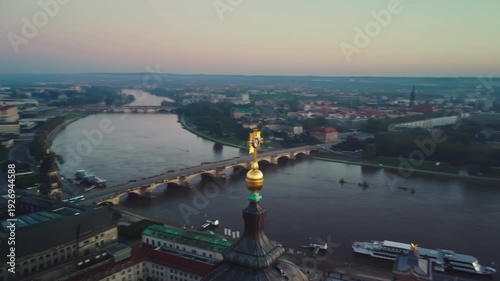 A circular aerial shoot of dome of the golden Dresden Orb and Cross on top of the Frauenkirche with Dresden's Old Town and the River Elbe behind in Dresden in Germany