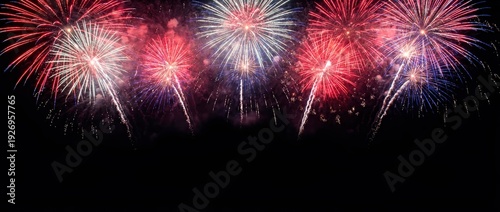 Colorful fireworks display against a black night sky. Red white and blue pyrotechnics for celebration. Independence Day background
