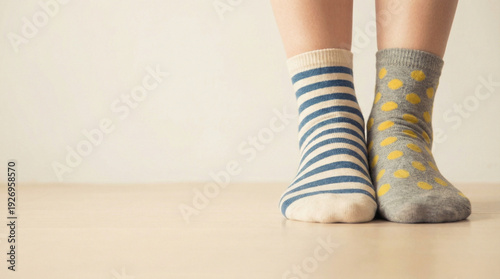 Colorful striped and polka dot socks on feet concept of World Down Syndrome Day  
