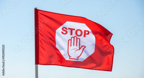 Red stop flag waving in the wind with white stop sign.