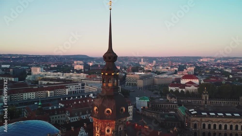 A pulling back aerial shoot of Cathedral of the Holy Trinity, also known as the Katholische Hofkirche with Dresden's Old Town  behind in Dresden in Germany at dawn