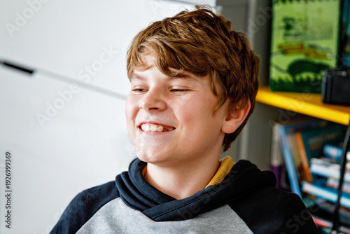Indoor portrait of happy smiling school kid boy during gaming and playing pc with friends. Handsome healthy child laughing