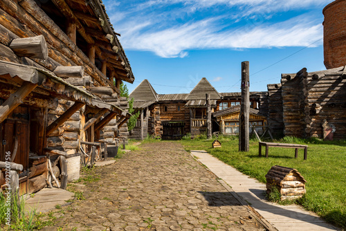A reconstructed Old Slavic fortress, built of round, hewn logs. A bright sunny day. The courtyard is surrounded by living quarters.