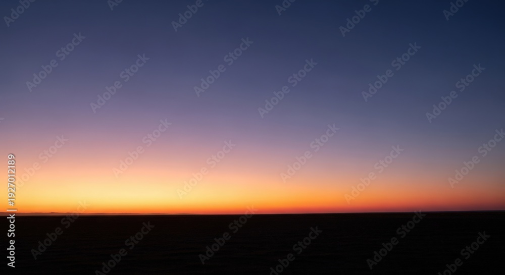 Fototapeta premium Minimalist horizon sunset with orange glow over dark vast landscape