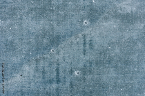 Abstract frozen agricultural field marked with scattered craters and straight lines creating a unique winter texture, aerial top view