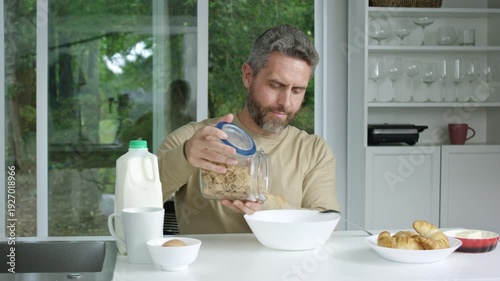 Man preparing breakfast in the kitchen at home. Kitchen morning concept with a man focused on nutrition. Man enjoying a nutritious morning meal in the kitchen. Morning kitchen.