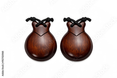 Pair of polished wooden castanets with black strings on a black background