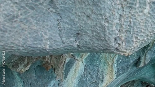 Patagonia's magnificent Marble Caves reveal their intricate beauty. Crystal clear, emerald water flows beneath ancient, artfully carved stone arches, inviting tranquil exploration.