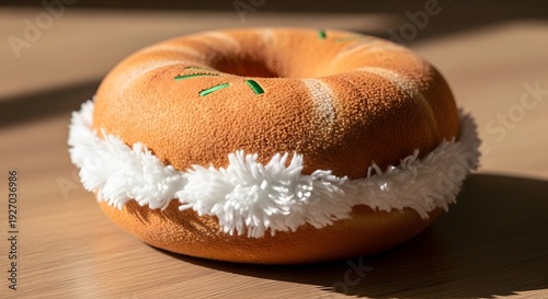 Close-up of a delicious frosted donut with green sprinkles on a wooden surface.