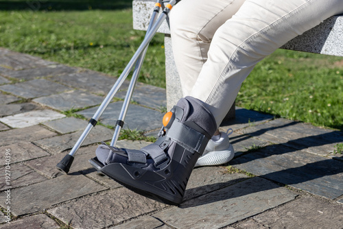 Φωτογραφία close up of a cam walker on a person with crutches resting from an ankle injury