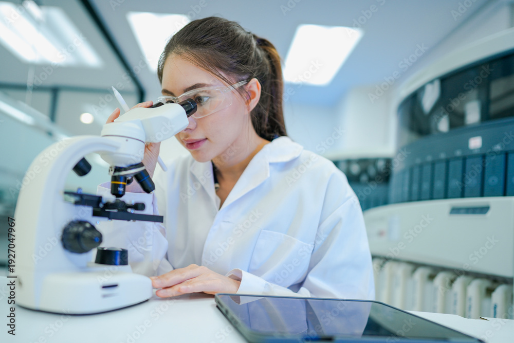 Obraz premium Medical technologist validating automated analyzer results against microscopic observations. Biomedical engineer configuring diagnostic instrument parameters using digital control interface.