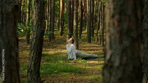 Woman meditates, relaxes and make yoga exercises in the woods alone