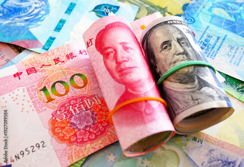 Chinese yuan, US dollars among various currencies background. Banknotes different countries denominations. Chinese yuan, US dollars and foreign currencies. World's reserve currency in global trade.