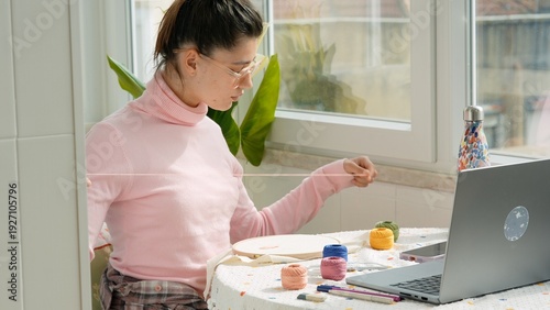 Female with yarn arranging colors while enjoying sunny balcony view