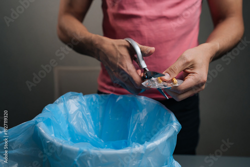Person disposing of expired medication safely by cutting blister packs with scissors, preventing accidental ingestion and misuse, promoting responsible pharmaceutical waste management
