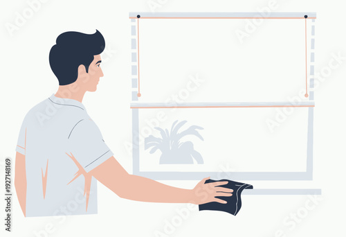 Man cleaning a window with a cloth while standing indoors, emphasizing cleanliness, home maintenance, and household chores for a tidy living environment