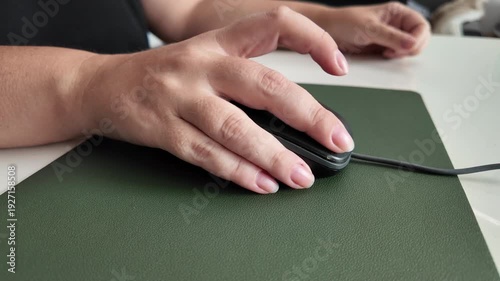 Female using mouse on mouse pad and desk, detail of modern work environment