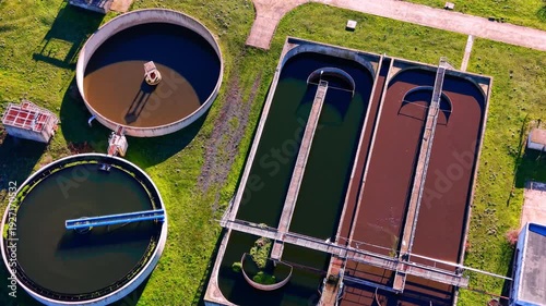 Various shapes of aeration and sedimentation tanks at a wastewater facility. Aerial view of rectangular and circular water treatment basins.
