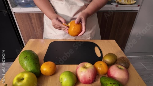 The process of cleaning a mandarin orange. A woman's hands clean a fresh orange