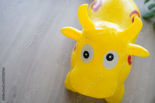 Children's toy in the form of a jumping cow. It is yellow in color.