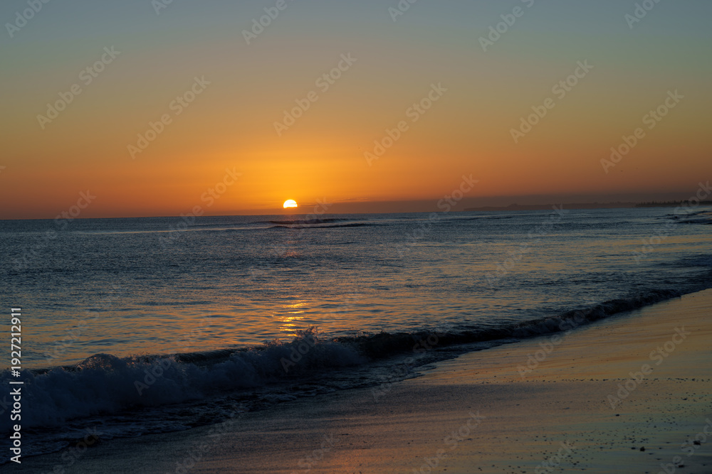 Obraz premium Warm tones of small sphere of sun rising over distant horizon