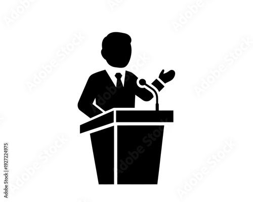 Man Speaking at Podium with Microphone.