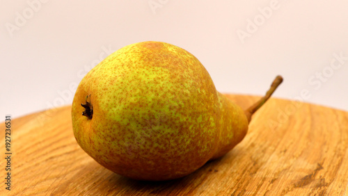 Obraz na płótnie Realistic green pear with stem on wooden board