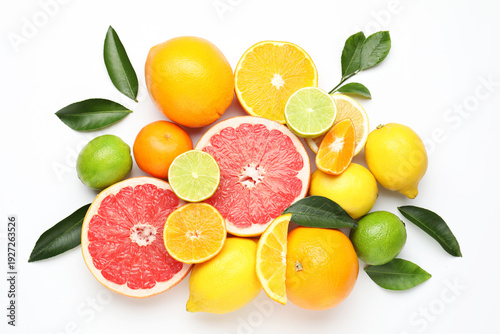 Fotografie Different fresh citrus fruits and green leaves on white background, flat lay