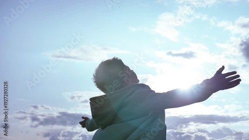 Sunlit Wonder: Boy Lost in Awe as He Embraces the Sunlight and Gazes Upward