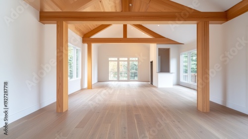 Spacious interior with timber beams, white walls, wooden floors and large windows. Natural light floods the room. Luxury home, open concept, architectural design, modern cabin