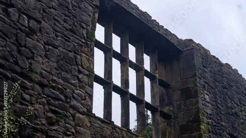 Whalley Abbey ancient, old, ruins. Stone masonry and preserved window opening with stone lintels against a cloudy sky
