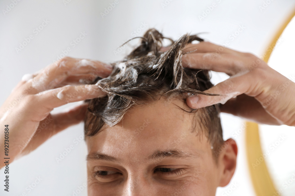 Naklejka premium Man washing his hair with shampoo in bathroom, closeup