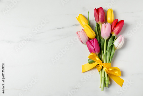 Beautiful colorful tulip flowers on white marble background, top view. Space for text
