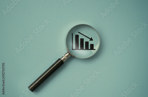 Φωτογραφία magnifier over the decreasing or descending graph