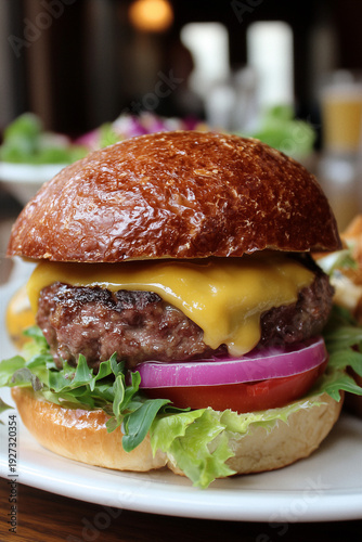Juicy cheeseburger close-up with melted cheddar, lettuce, tomato and red onion
