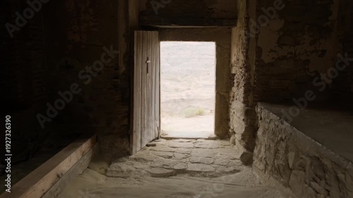 Walking towards open doorway onto captivating nature from dark room.