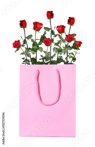 Red roses in paper bag on white background. Romantic gift