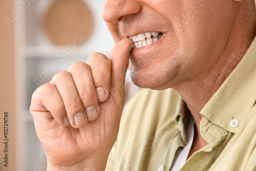 Worried mature man biting n...
