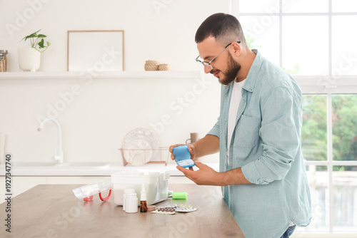 Young man with pill box and...