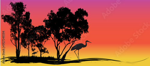 sunset silhouette of cranes and trees  with vibrant sky