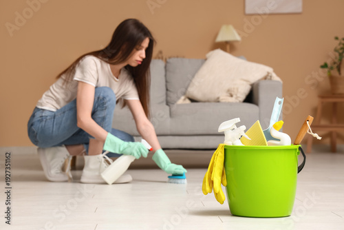 Young woman cleaning floor ...