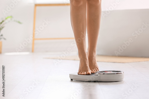 Legs of woman on weight scales at home