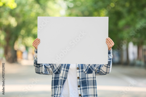 Young woman holding blank p...