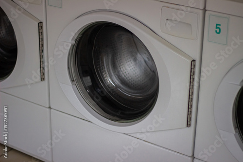 Wallpaper Mural Row of modern front loading washing machines in laundromat Torontodigital.ca